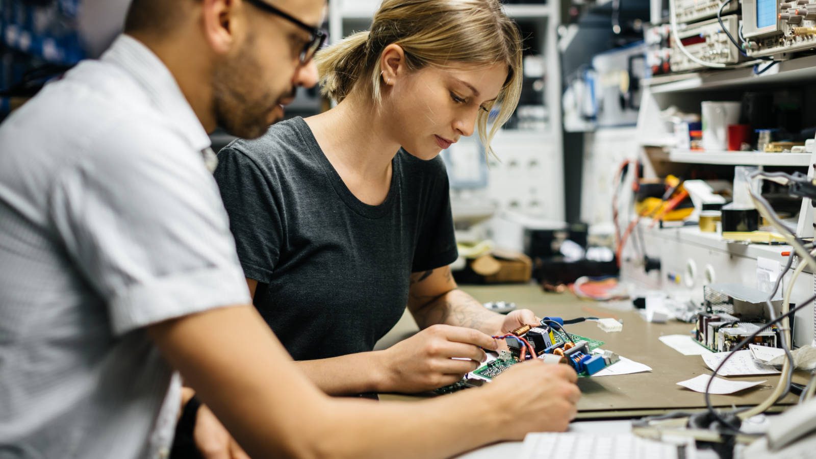 Two engineers Working On electronical Device