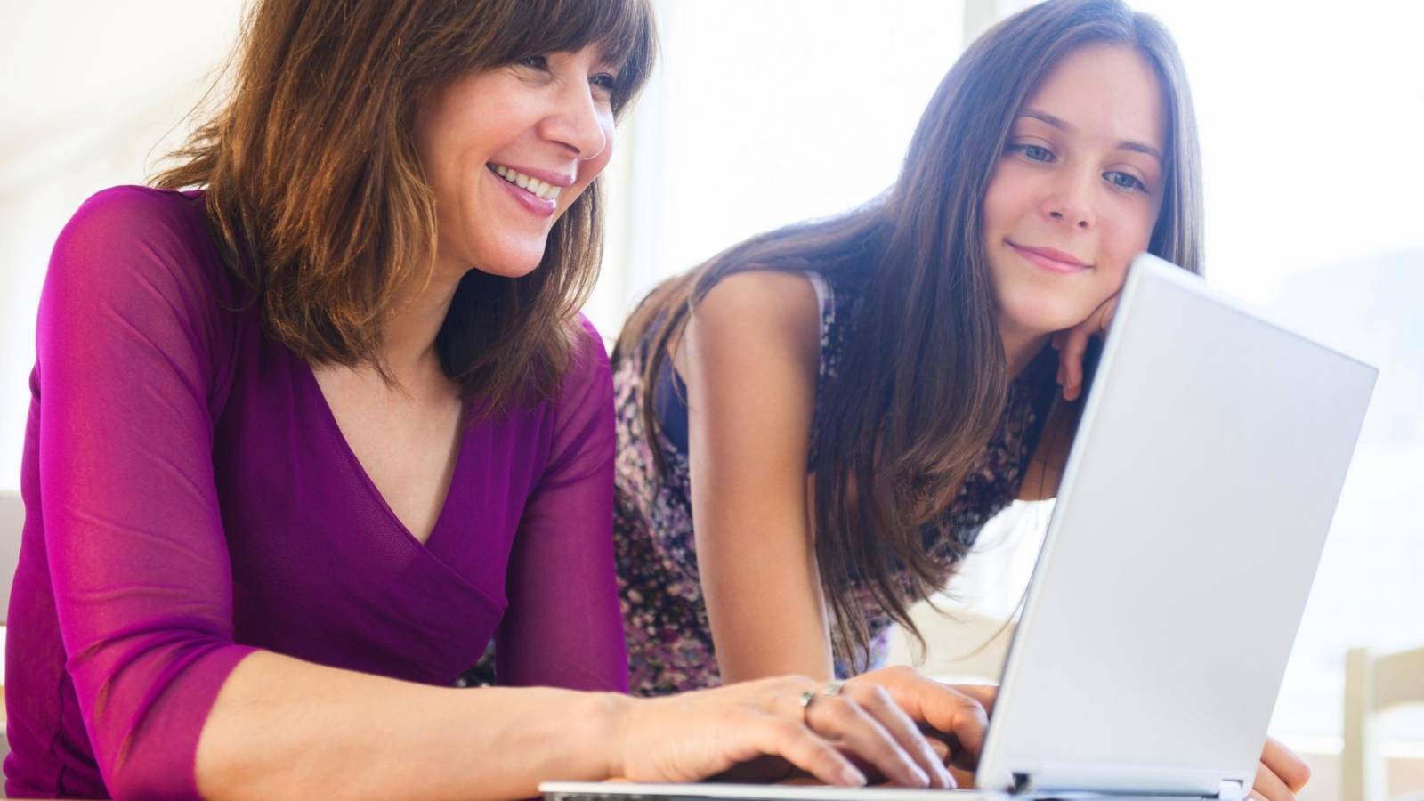 USA, New Jersey, Teenage girl (14-15) using laptop with her mom at home