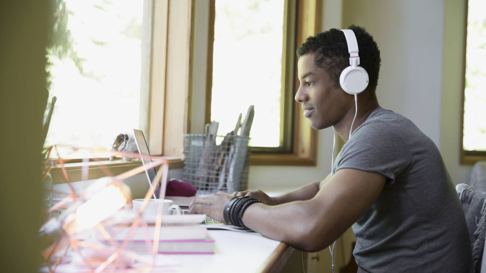 Man with headphones using laptop in home office