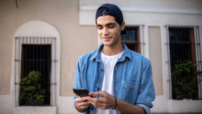 Teenager boy using the mobile phone outdoors