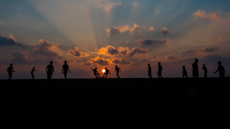 Children's Beach Football Match  during Sunset