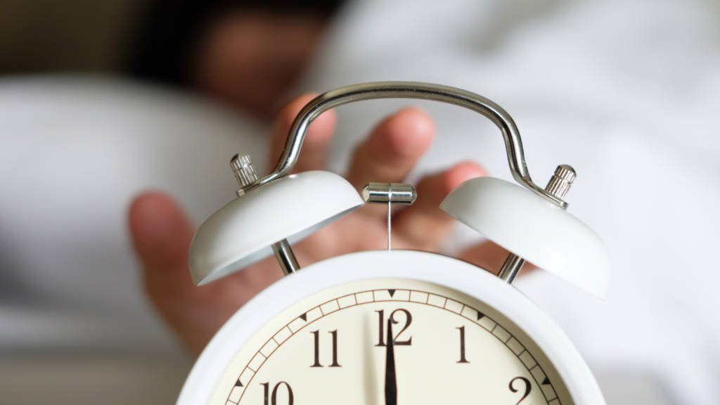Cropped Hand Of Person Turning Off Alarm Clock