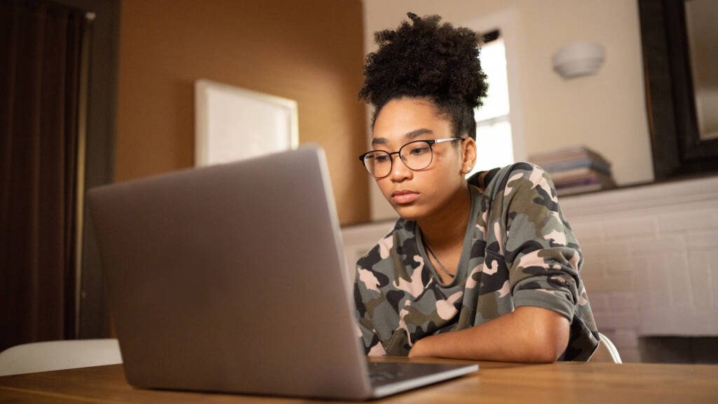 Student on a laptop at home researching how to pay for college without help